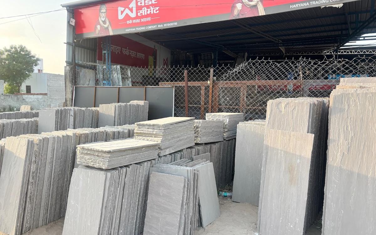 Rows of cut grey sandstone slabs in front of the Haryana Trading Company shed